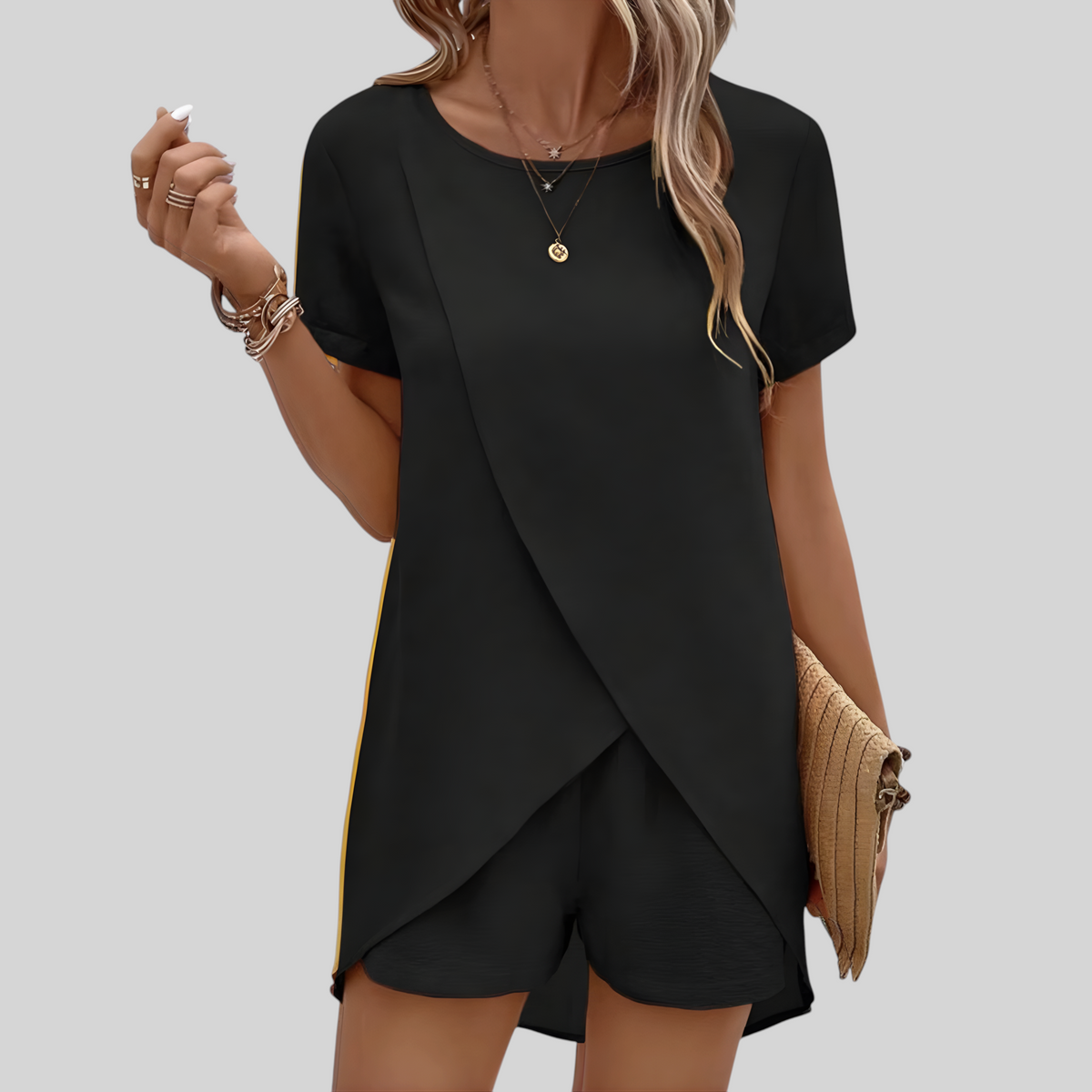 Model draagt een zwarte Wattle & Vale Melbourne Rebecca zomerse lounge set met een asymmetrische top en bijpassende short