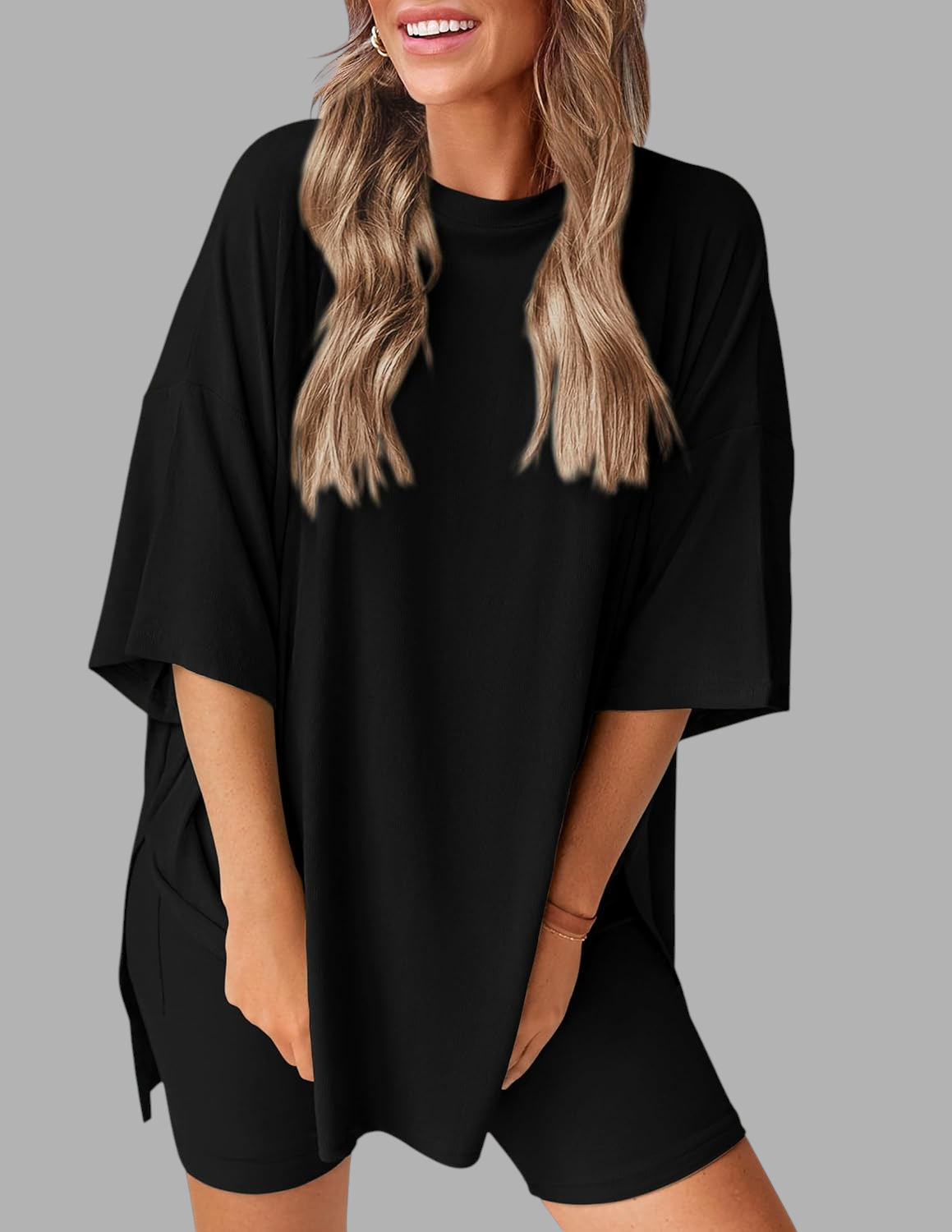 Vrouw draagt zwarte Wattle & Vale Melbourne Nina 2-delige lounge set met oversized tuniek en bijpassende biker shorts.