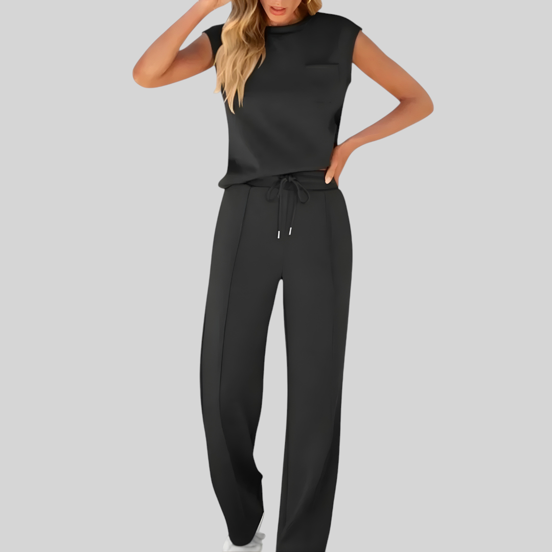 Vrouw draagt zwarte Wattle & Vale Melbourne Taylor lounge set met mouwloze top en wijde broek met trekkoord.