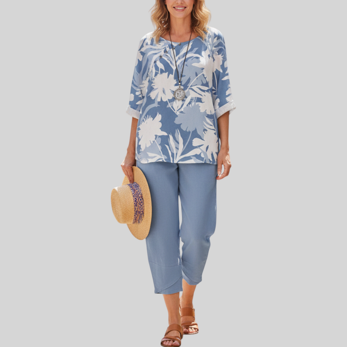 Vrouw draagt Wattle & Vale Melbourne Odessa tweedelige set met blauwe bloemenprint top en bijpassende broek op terras